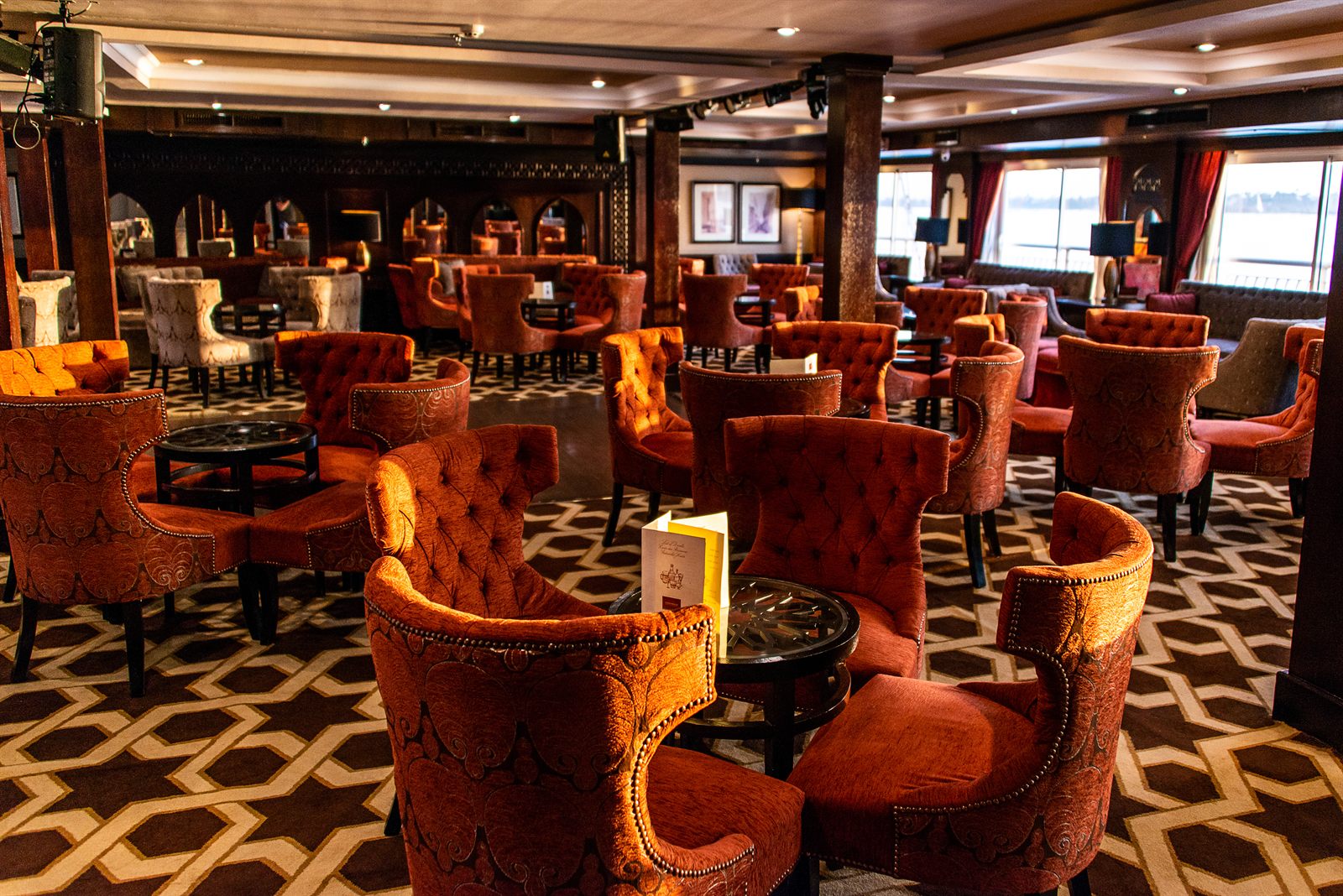 Elegant lounge with orange velvet armchairs and patterned carpet, the setting for an evening of travel advisor awards