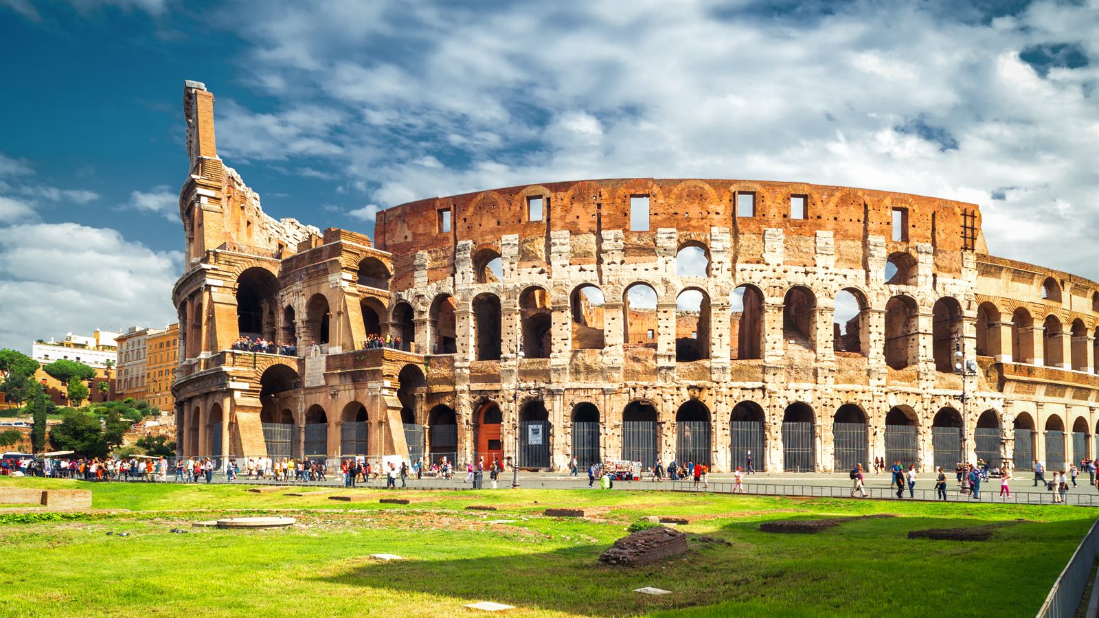 The Colosseum in Rome under a blue sky with clouds